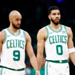 Boston Celtics guard Derrick White (9), forward Jayson Tatum (0) and guard Jaylen Brown (7) walk onto the court during the first quarter in game one of the second round of the NBA Eastern Conference playoffs at TD Garden.