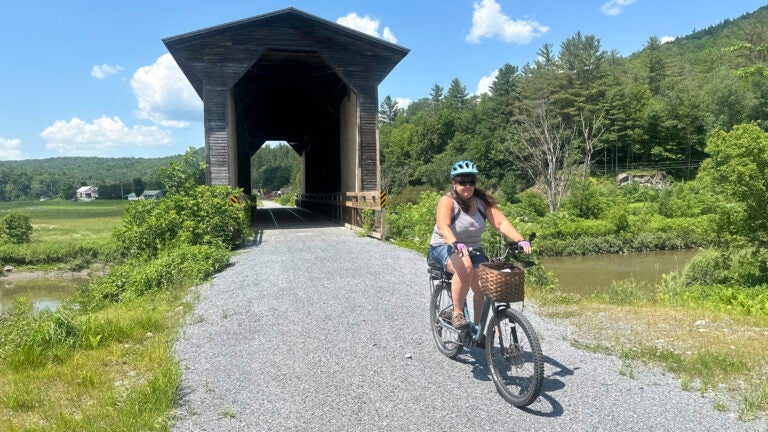 Claire Mayo of Woodbury, Vt., comes out of the Fisher Covered Bridge in Wolcott, Vt.