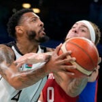 Isaiah Pineiro, right, of Puerto Rico, tries to stop a shot by Carlik Jones, of South Sudan, in a men's basketball game at the 2024 Summer Olympics in Villeneuve-d'Ascq, France.