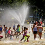 Children cool off in the Frog pond.