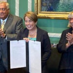 Massachusetts Gov. Maura Healey, center, shows the signed a nearly $58 billion state budget bill Monday, July 29, 2024, in Boston, that includes a plan for free community college and allows the Massachusetts Lottery to move some of its products online.