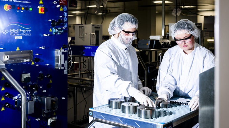 Employees in a lab focused on cancer vaccine research at a Moderna facility in Norwood, Mass.