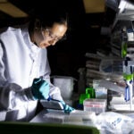 A researcher works in the lab at the Moderna headquarters in Cambridge, Mass.