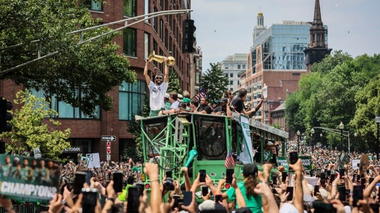 Boston Celtics forward Jayson Tatum (0) holds up the Larry O'Brien Championship Trophy during a duck boat parade to celebrate the 18th Boston Celtics NBA championship.