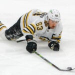 Boston Bruins left wing Brad Marchand (63) controls the puck after getting tripped and penalized by Florida Panthers center Anton Lundell (15) during first period of game two of the Eastern Conference NHL second round Playoff game at Amerant Bank Arena.