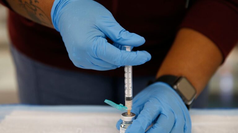 A medical professional prepares a COVID vaccine.